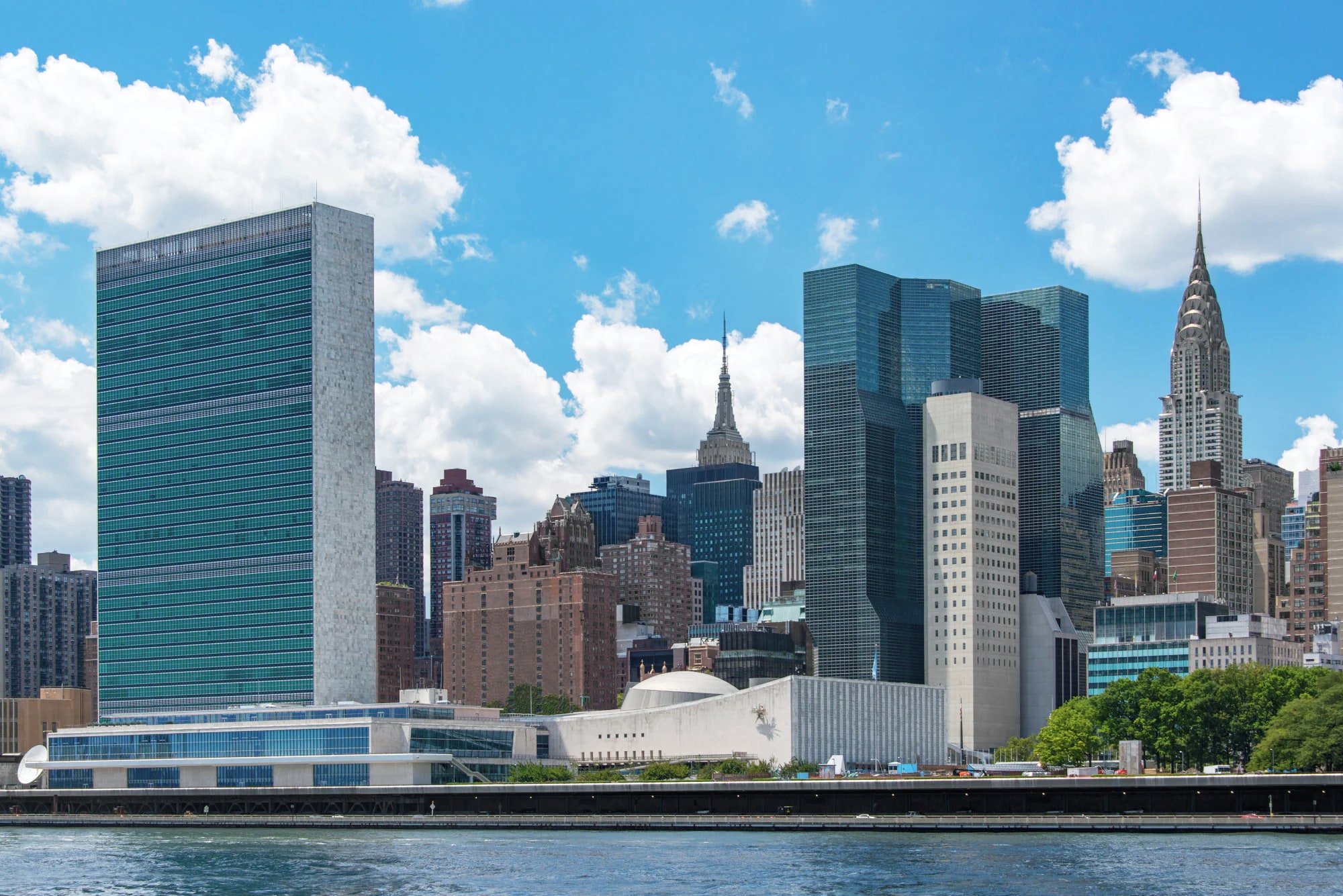United Nations General Assembly building and New York City skyline featuring a Siplast commercial reroofing installation.