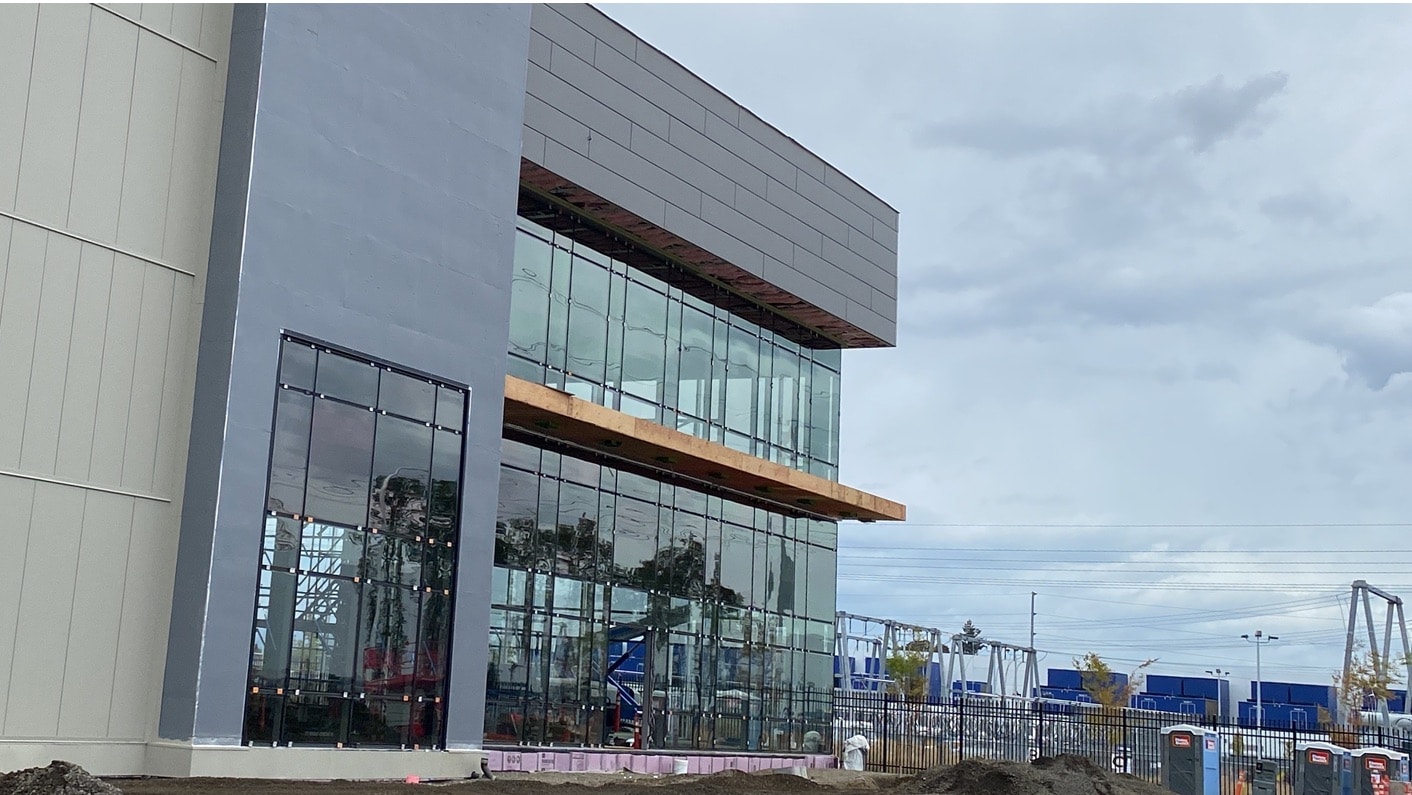 Exterior of a T5 Data Center under construction, featuring large glass windows and gray paneling.
